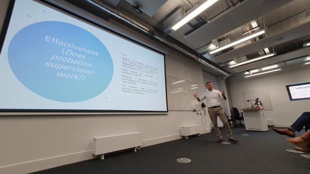 Photo of Peter Beck, Probation Officer, in front of his powerpoint presentation on 'Desistance and Probation Practice' at the Coffee and Learn Seminar in Ulster University, Belfast 