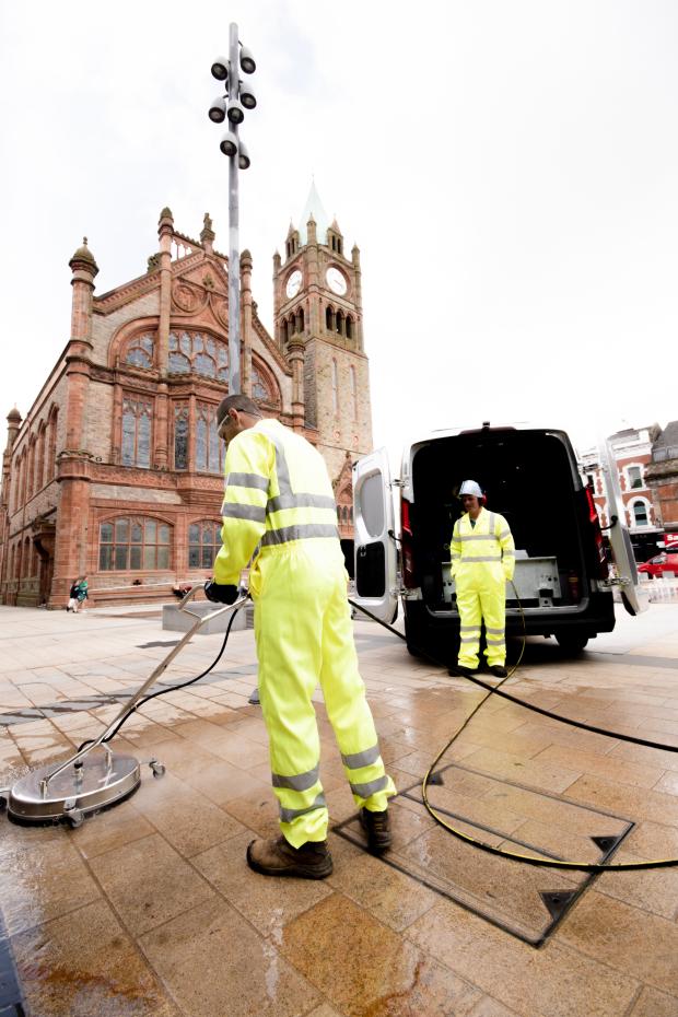 A service user removing graffiti from outside the Guild Hall, Derry City and Strabane District Council